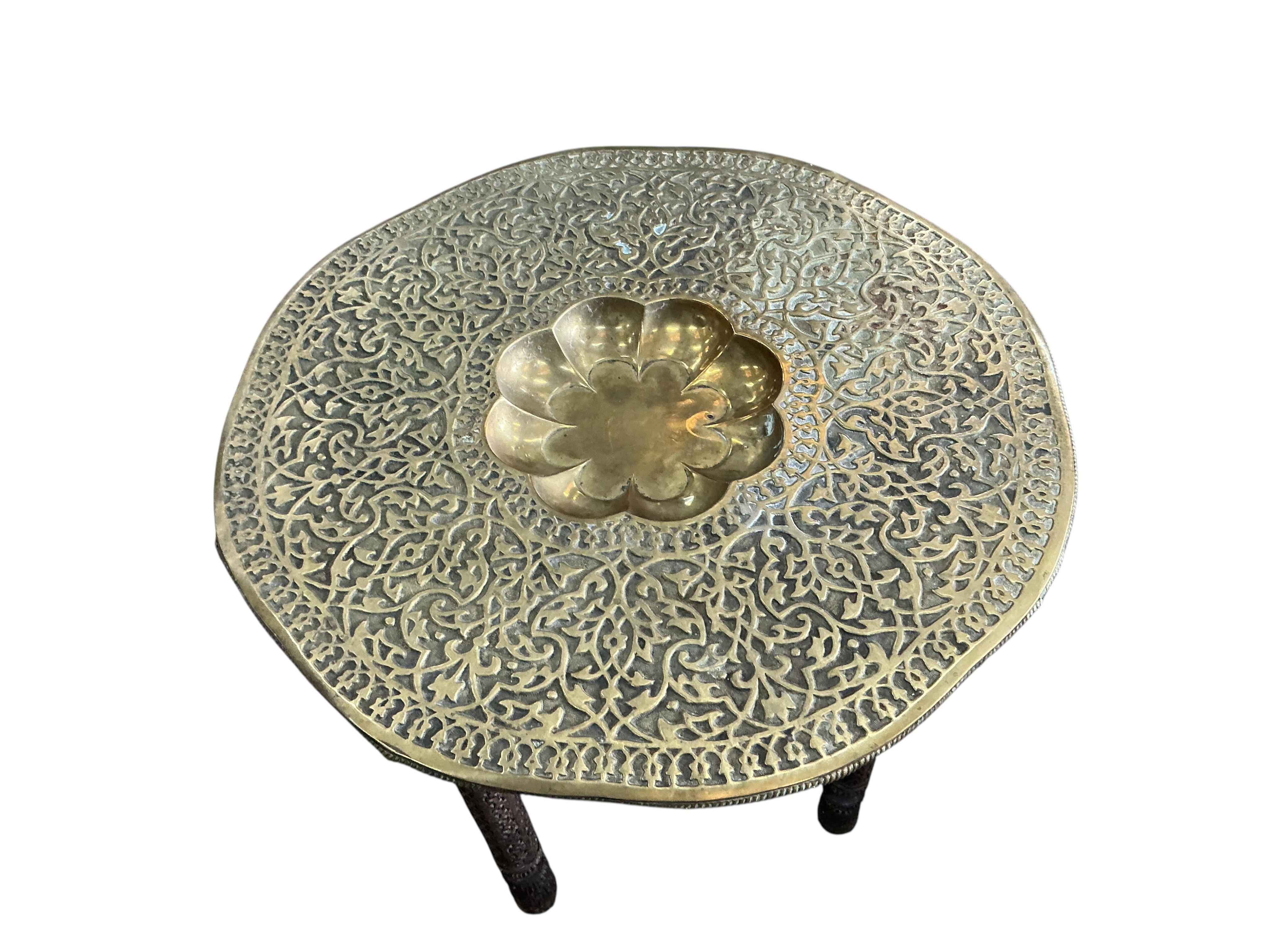 A brass tray top table on folding hardwood stand, diameter 76cm, height 57cm